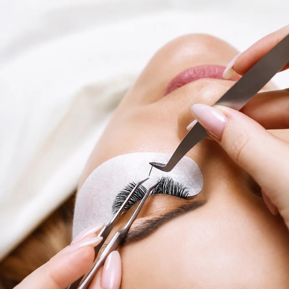A lash artist placing individual lash extensions